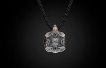 Silver Krypton pendant featuring intricate etched designs, a central circular emblem, and wing-like elements, on a black braided cord.