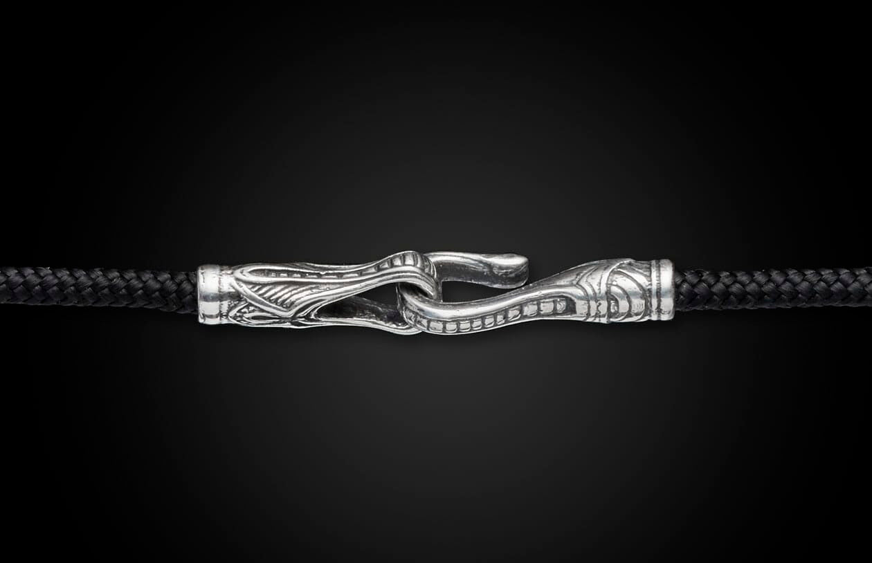 Black braided cord jewelry with an ornate silver hook clasp featuring intricate scrollwork designs.
