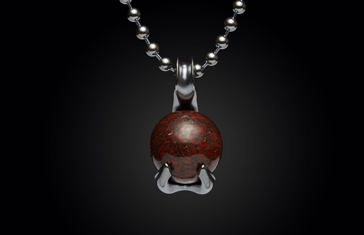 Dark red patterned gemstone pendant with a stylized silver swan-like setting on a ball chain.
