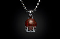 Dark red patterned gemstone pendant with a stylized silver swan-like setting on a ball chain.