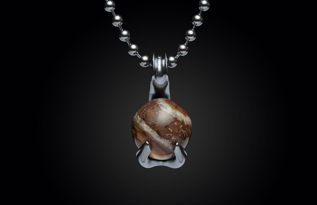 Silver ball chain necklace with a round, swirling brown and white stone pendant held by a metallic claw setting.