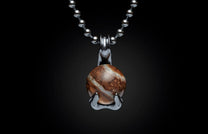 Silver ball chain necklace with a round, swirling brown and white stone pendant held by a metallic claw setting.