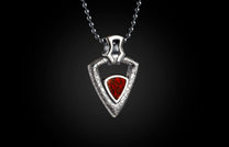 Triangular silver pendant with a textured finish and a red fossilized inlay, hanging from a metal bead chain.