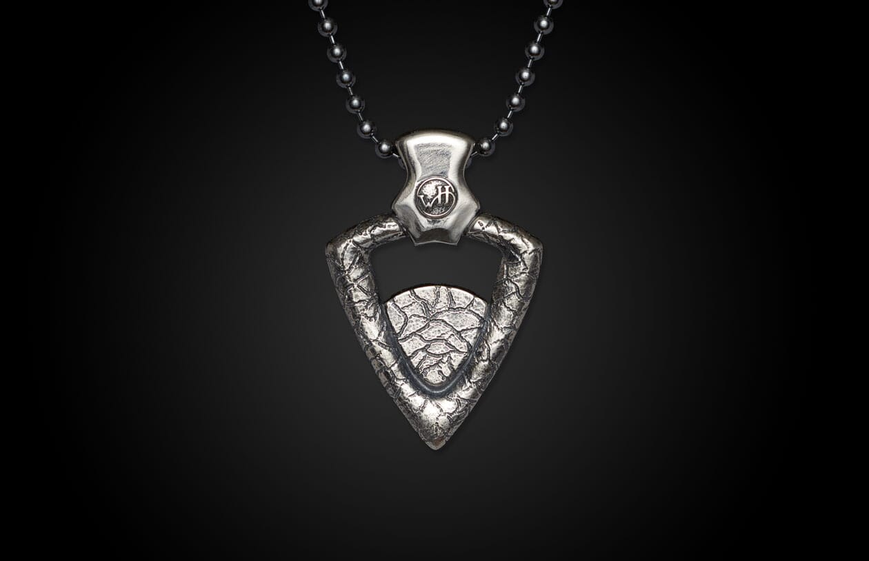 Silver-toned pendant on a ball chain, featuring a triangular textured design and "WH" emblem.