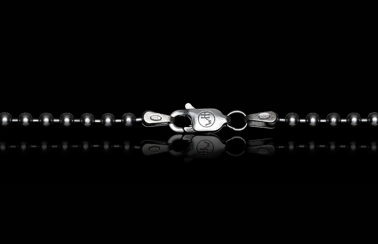 Silver ball chain with lobster clasp featuring WH logo and 925 stamp on a reflective black surface.