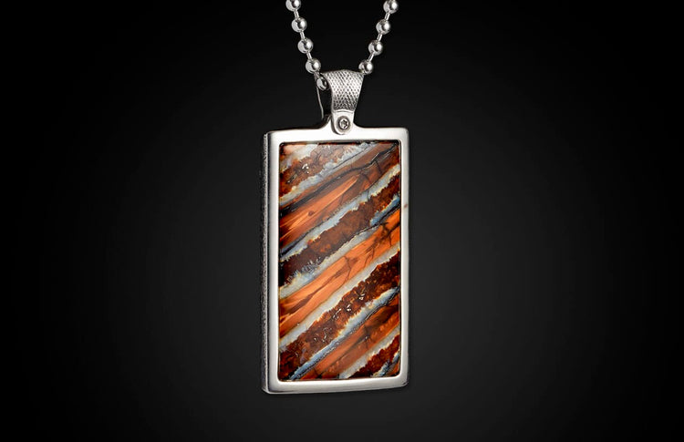 Rectangular silver-toned pendant featuring a striped stone in warm orange, brown, and white, suspended from a ball chain.