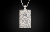 Silver rectangular pendant with cracked texture, a 'WH' emblem, and a ball chain.