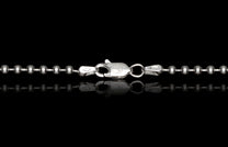 Silver ball chain necklace with an engraved lobster clasp, displayed with a mirrored reflection.