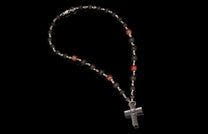 Black lava stone beaded rosary with reddish-brown accent beads and a textured silver-tone cross pendant.