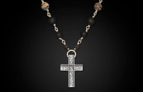 Textured silver cross pendant necklace with black lava beads and striped accent beads.