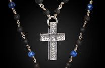 Sodalite and lava stone beaded necklace with a silver cross pendant featuring a distressed, grid-like texture.