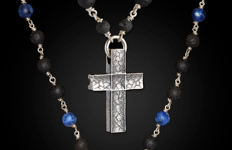Sodalite and lava stone beaded necklace with a silver cross pendant featuring a distressed, grid-like texture.