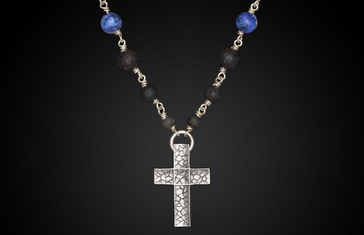 Silver textured cross necklace with blue Sodalite and black lava beads.