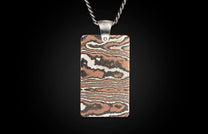 Rectangular metal pendant with a silver chain and bail, featuring a swirling woodgrain pattern in copper, silver, and dark tones.