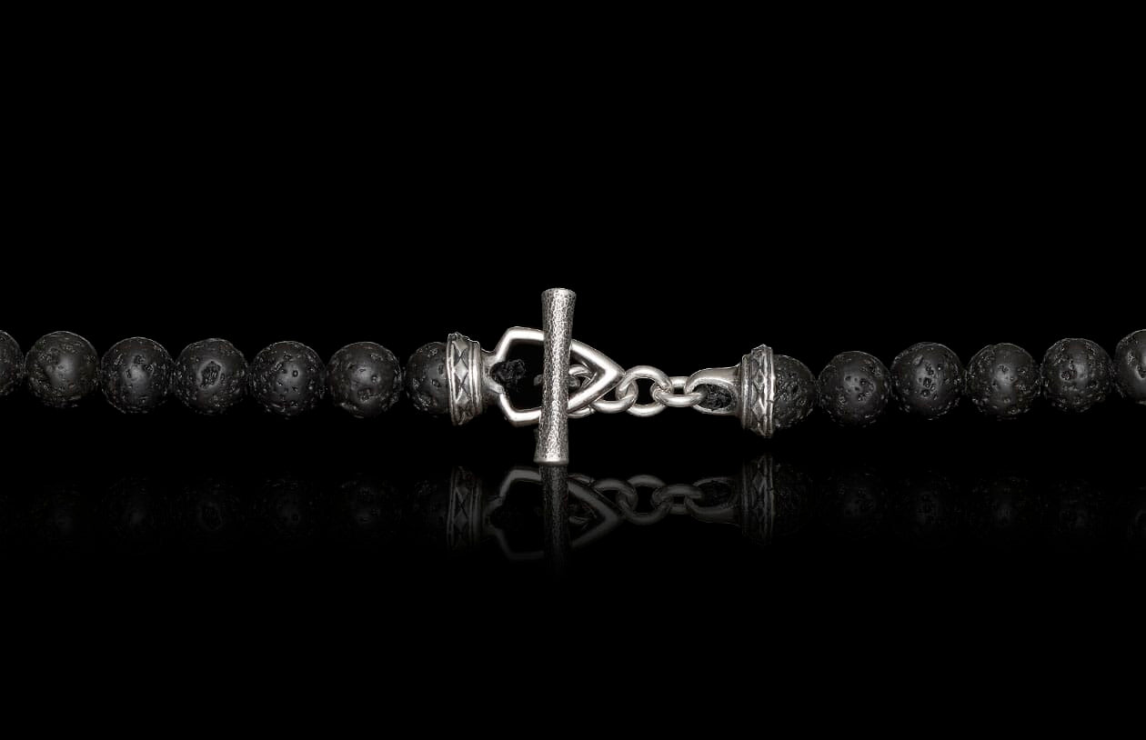 Black porous beaded necklace or bracelet with a silver-toned toggle clasp featuring a textured bar and ornate end caps.