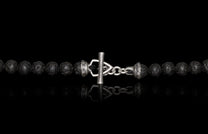Black porous beaded necklace or bracelet with a silver-toned toggle clasp featuring a textured bar and ornate end caps.