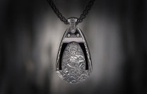 Silver warrior pendant with ornate details, depicting a crowned figure, hanging from a dark chain.