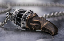 Silver and bronze King's Claw pendant with a spiked cage design and a textured claw, on a silver chain.