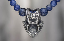 Sodalite Shield jewelry with a detailed silver-toned metal pendant featuring a keyhole design and 'WH' initials, strung with dark blue sodalite beads.