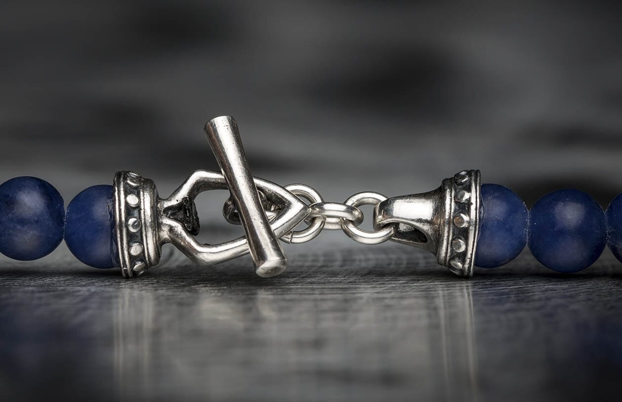 Sodalite bead bracelet with a silver metal toggle clasp, featuring ornate silver end caps and matte blue sodalite beads.