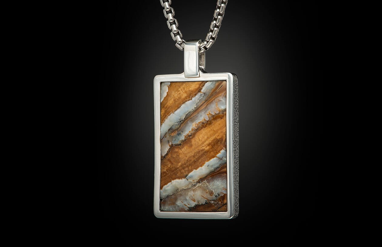 Rectangular silver pendant with a brown, white, and grey banded mammoth ivory stone on a silver chain.
