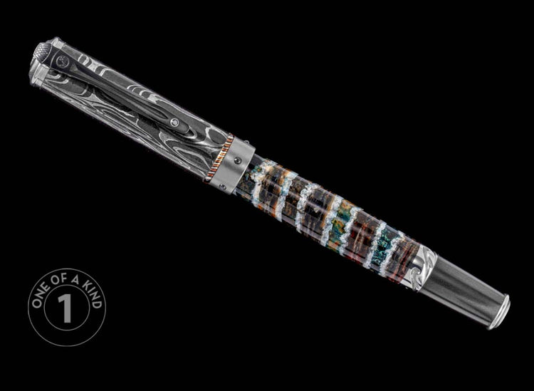 One of a Kind custom pen from William Henry featuring a fossil mammoth tooth barrel, hand forged Damascus steel cap, Spinel gemstone, and titanium accents.