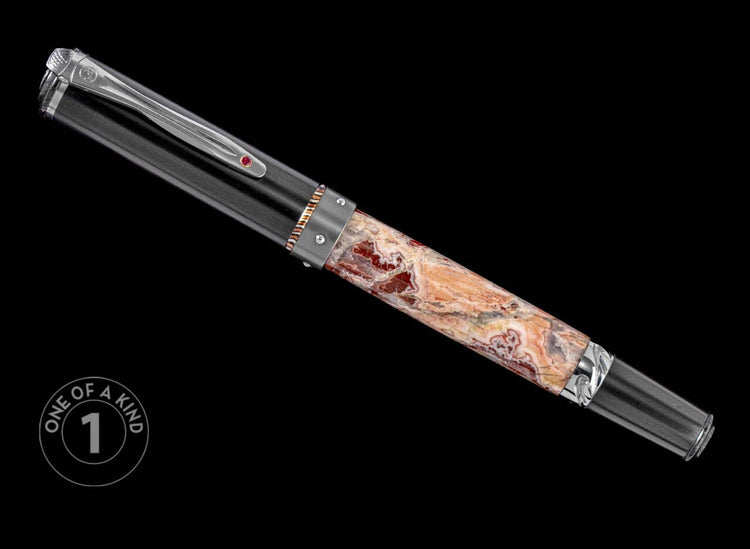 One of a Kind pen from William Henry featuring a leopard skin jasper barrel, carbon fiber cap, ruby gemstone, and Damascus steel accents.