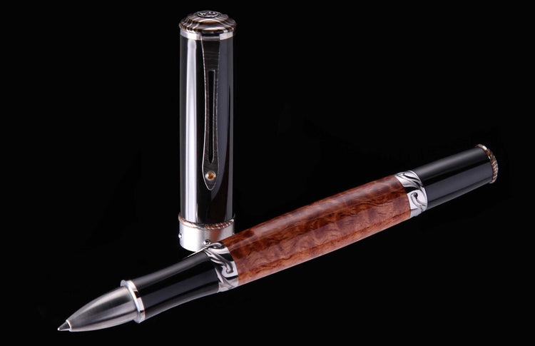 Luxury rollerball pen with a rich brown burl wood barrel, black sections, and intricate silver-toned metal accents, displayed uncapped with the cap standing upright.