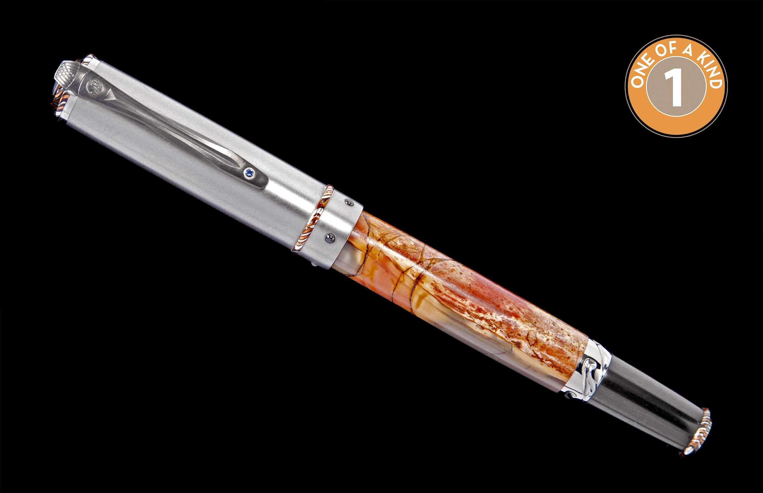 A luxurious pen with a brushed silver cap, a unique reddish-brown and cream patterned stone barrel, and a blue gem on its clip.