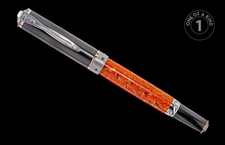 Dark grey and orange pen with a silver clip, copper accents, and a translucent speckled barrel.