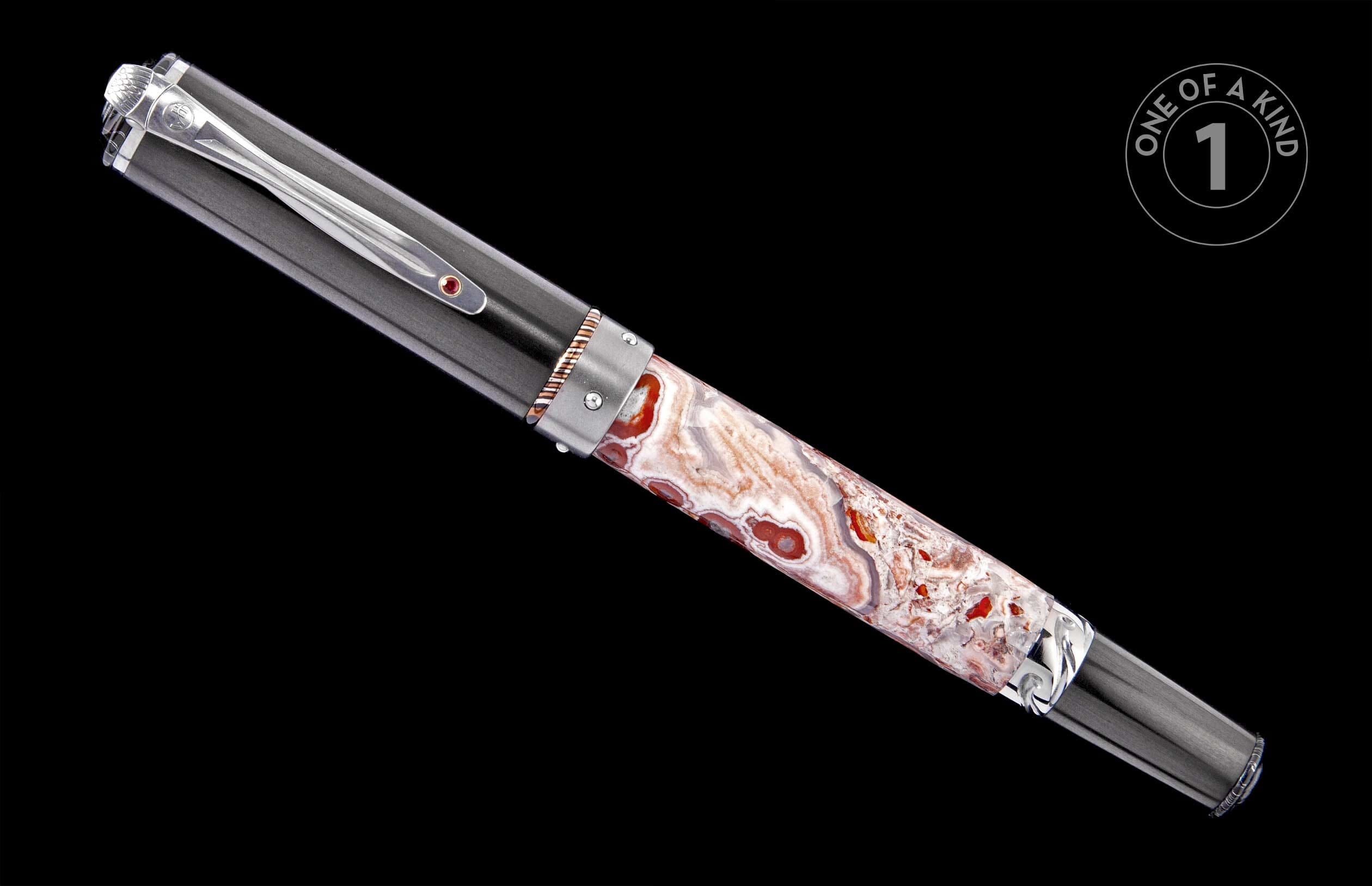 A luxury pen with a dark gray cap, a banded white, orange, and red agate-patterned barrel, and a silver clip with a logo and red gem.