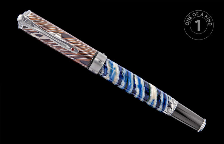 Pen with a damascus-patterned cap in silver and brown, and a swirled blue, white, and green resin barrel with a silver clip and red gem.