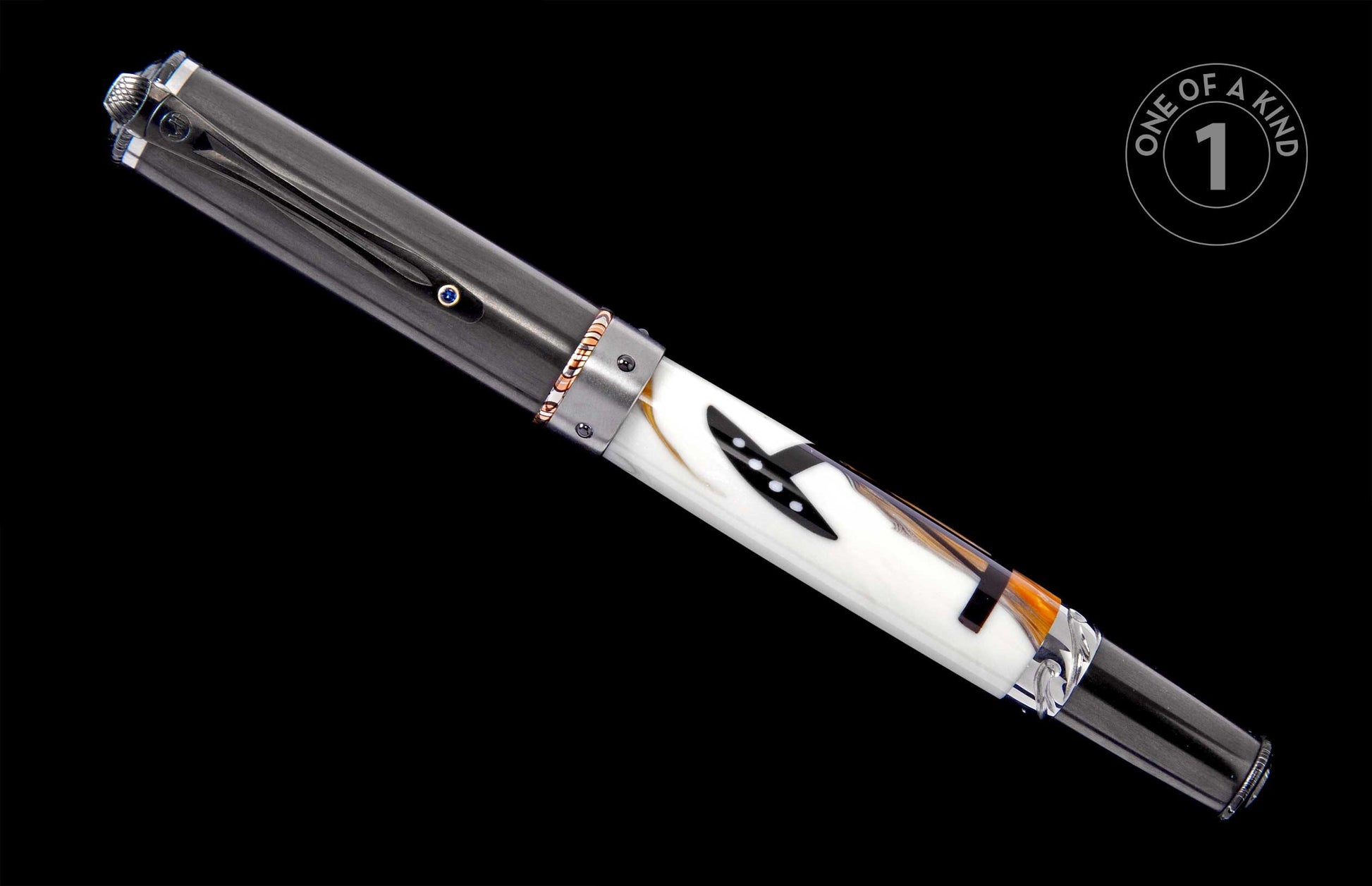 Dark gray and white fountain pen with a textured finial, blue jewel, and white barrel featuring black axe and orange feather patterns.