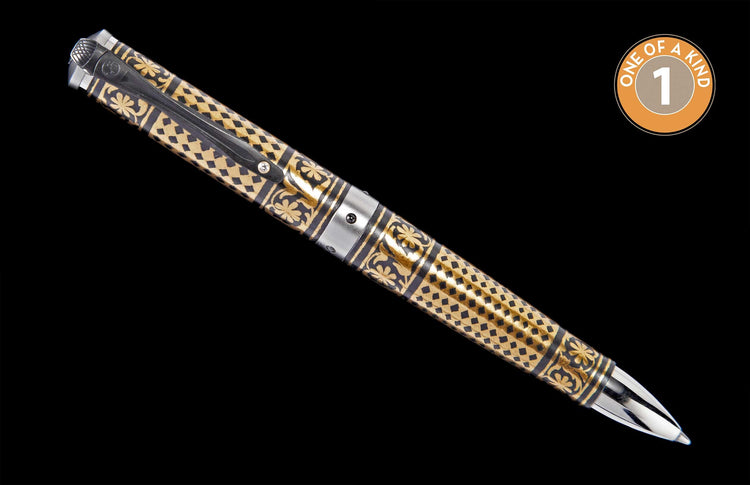 Ornate gold and black pen with intricate engraved diamond and floral patterns, featuring silver-toned accents and a black clip, angled on a black background.