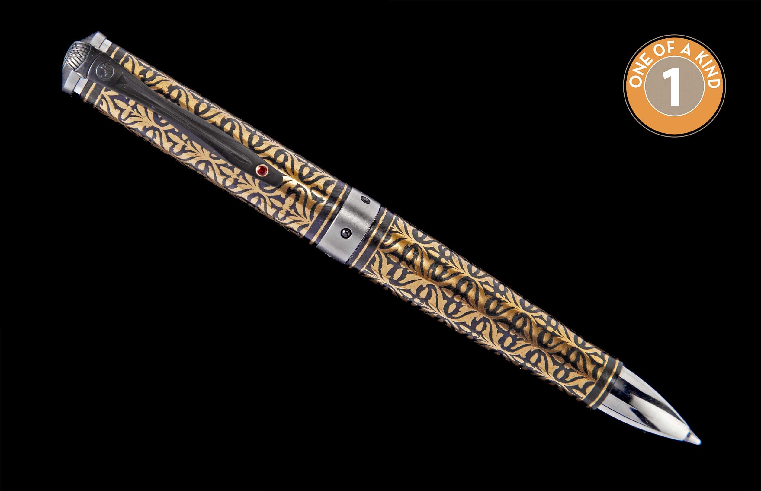 Ornate gold and black pen with intricate floral patterns, a red jewel, and a "ONE OF A KIND 1" emblem.