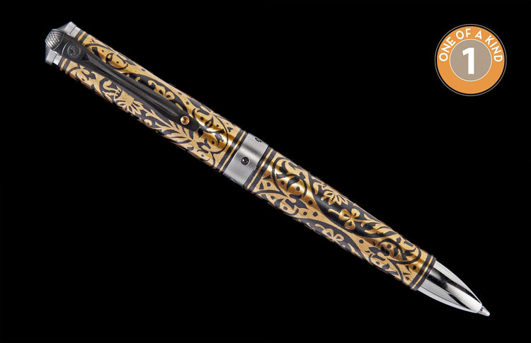 Ornate gold and black pen with intricate swirling patterns and metallic silver accents, angled diagonally. A 'one of a kind' badge is in the top right.