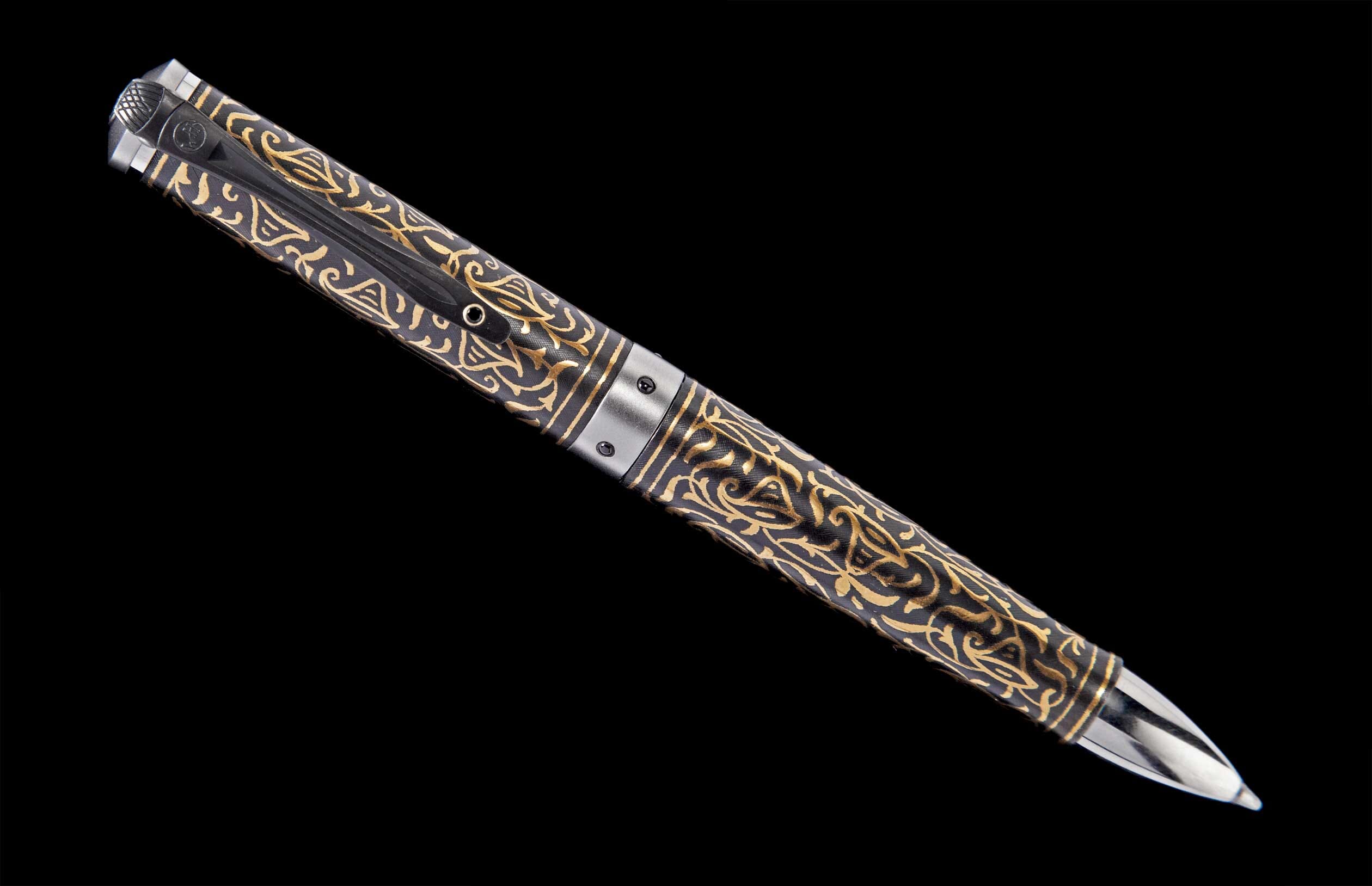Ornate pen with a dark body and intricate gold scrollwork, featuring a silver-toned clip and writing tip.