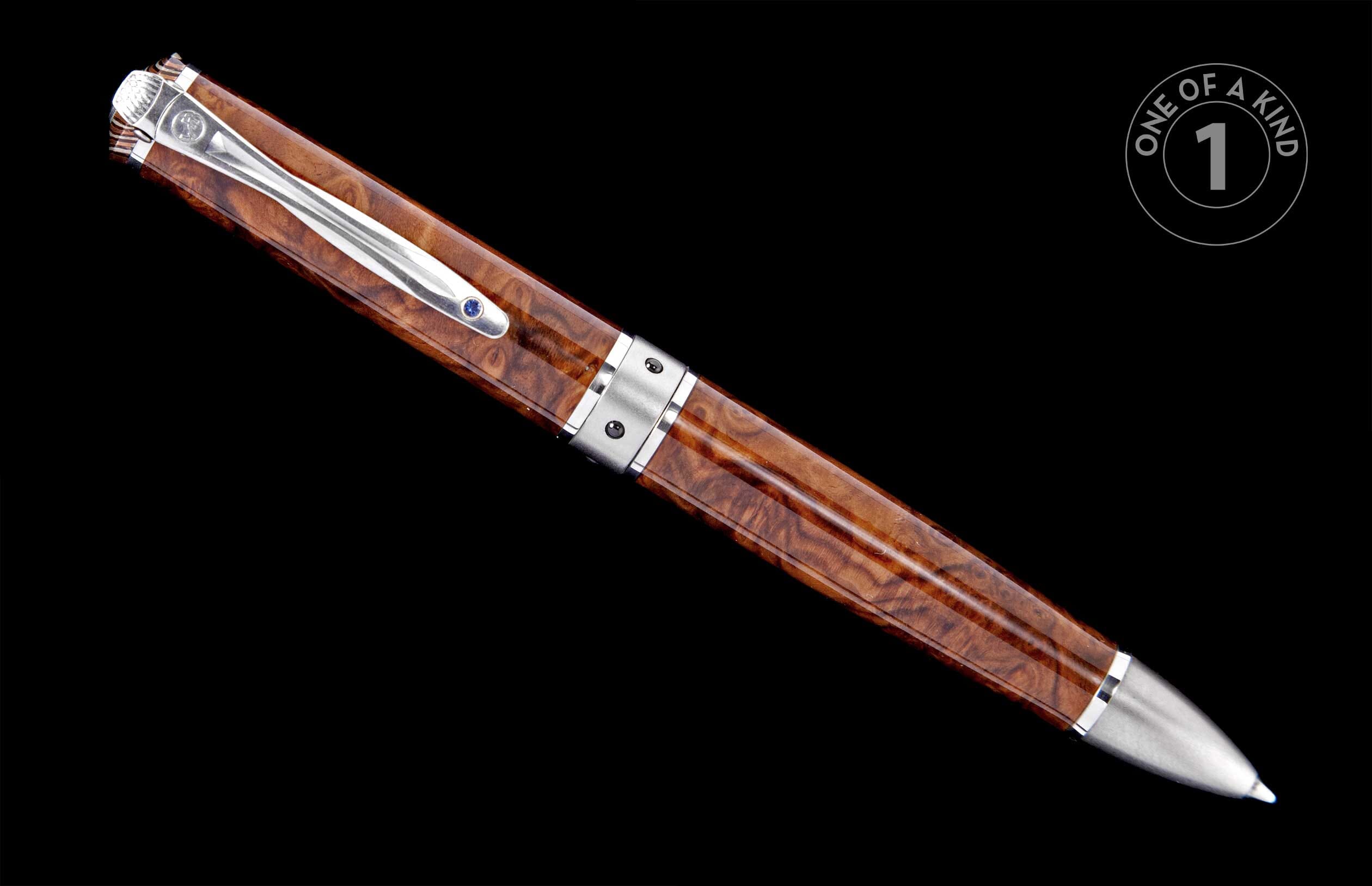 Elegant brown burl wood pen with silver-toned metal accents and a blue gemstone on the clip, angled.
