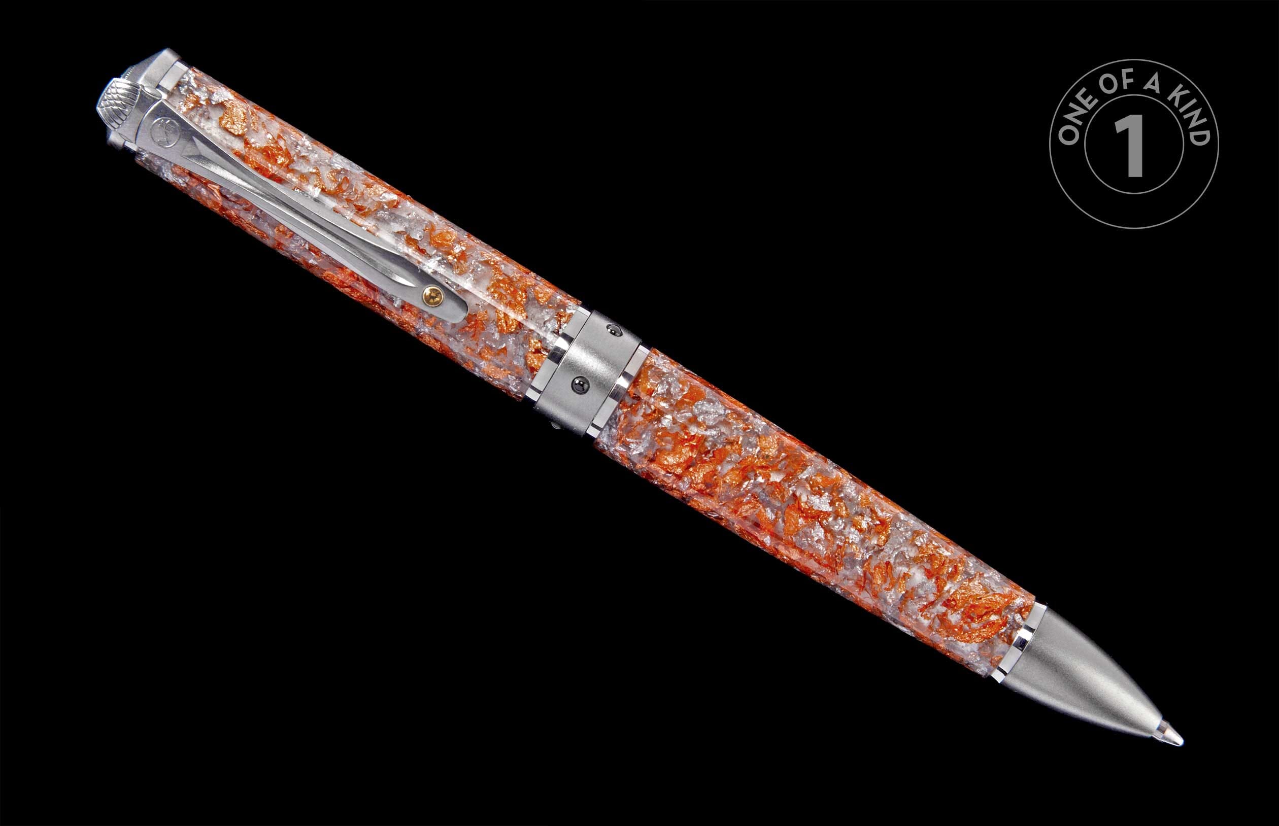 Pen with a clear barrel embedded with shimmering orange and silver flakes, featuring silver-toned metal details.