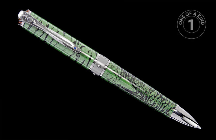 Green and black marbled pen with a silver clip featuring a blue jewel, displayed diagonally against a black background.