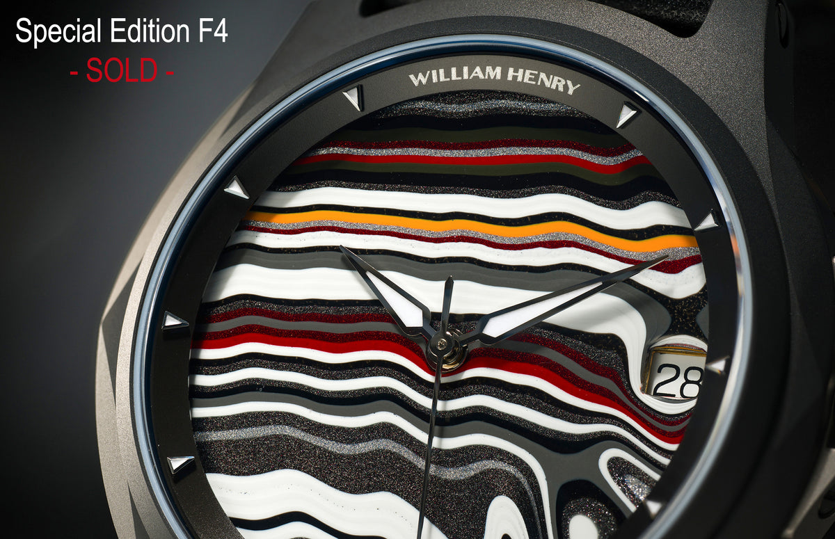 Special Edition Fordite watch by William Henry featuring multicolored striped dial with black, white, red, and orange layers, textured finish, and triangular hour markers in close-up view