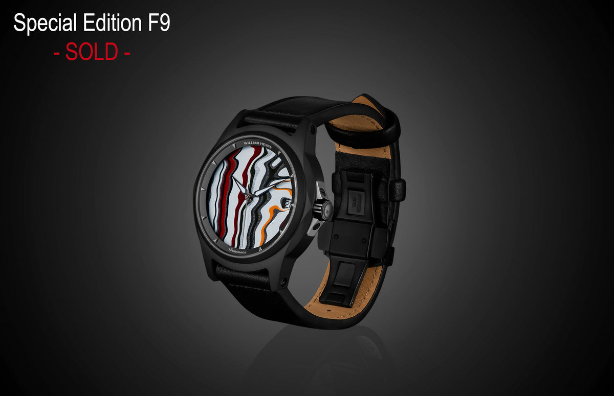 Special Edition Fordite watch by William Henry with marbled red, white, and black dial, black case, and leather strap, side view