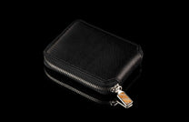 ZBF LIZ BLK MT|Black leather Zipper Bi-Fold with a subtle scale texture, silver zipper, and decorative striped pull, on a reflective surface.