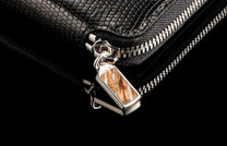 ZW LIZ BLK MT|Large black leather zipper wallet with a scaly texture, silver zipper, and a decorative pull featuring an orange and white inlay.
